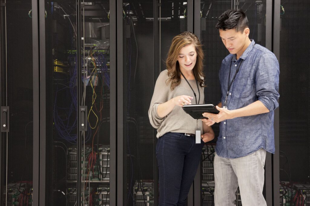 Woman and man looking at tablet in server room